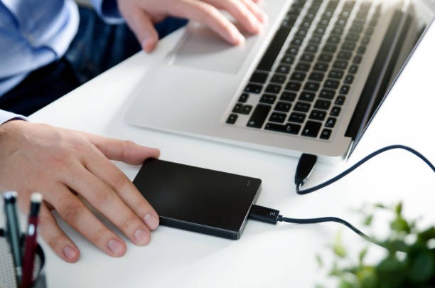 External hard drive connected to a laptop for data recovery purposes.